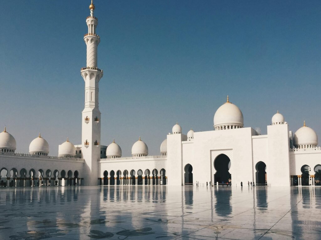 Beautiful view of Sheikh Zayed Grand Mosque with minarets and domes in Abu Dhabi under a clear blue sky.