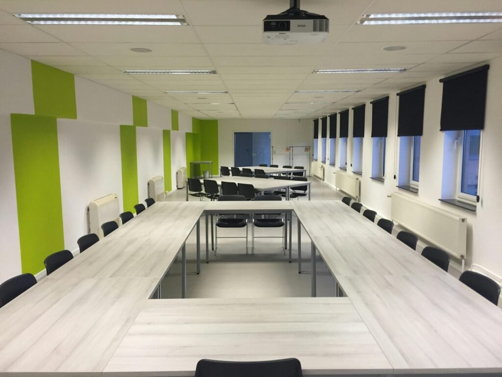 Spacious indoor meeting room with modern furniture and large windows.